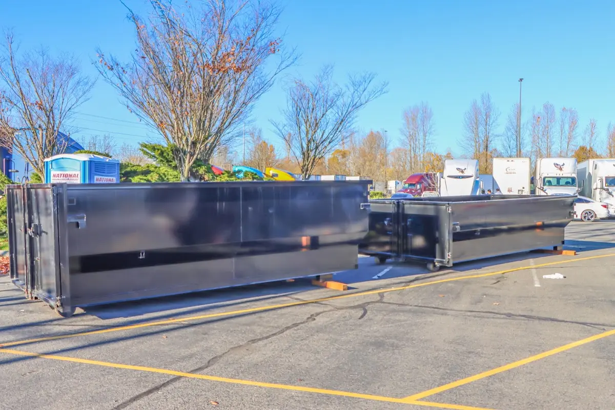 Professional dumpster rental service with roll-off container on residential driveway in Forestdale